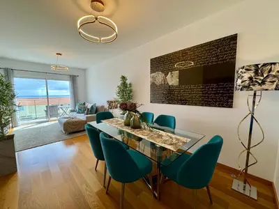 a dining room with a glass table and blue chairs at Welcome to Paradise Island in Caniço