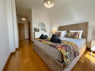 a bedroom with a bed with two bags on it at Welcome to Paradise Island in Caniço
