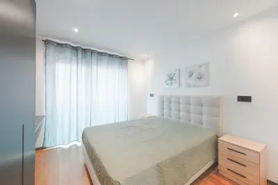 a white bedroom with a bed and a window at Best View Funchal Vacation Apartment in Funchal