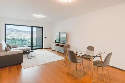 a living room with a glass table and chairs at Best View Funchal Vacation Apartment in Funchal