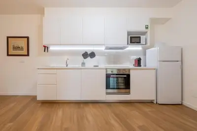 a kitchen with white cabinets and a refrigerator at Alamos Charming Apartments - Garden in Funchal