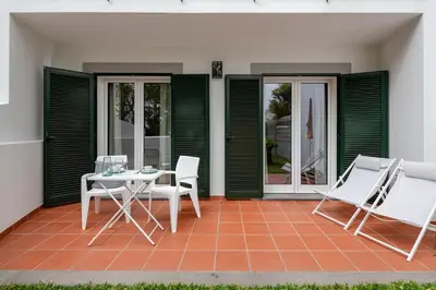 a patio with a table and chairs on a house at Alamos Charming Apartments - Garden in Funchal