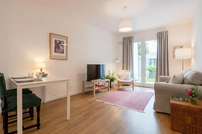 a living room with a couch and a table and a television at Alamos Charming Apartments - Garden in Funchal