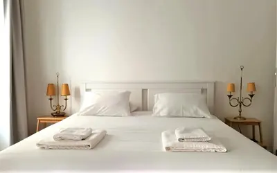 a white bed with two towels on top of it at Alamos Charming Apartments - Family in Funchal