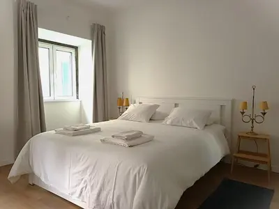 a white bed with two towels on top of it at Alamos Charming Apartments - Family in Funchal
