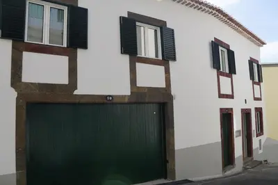 a building with a green garage door and windows at Alamos Charming Apartments - Family in Funchal