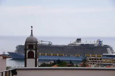 a cruise ship in the water with a clock tower at Alamos Charming Apartments - Family in Funchal