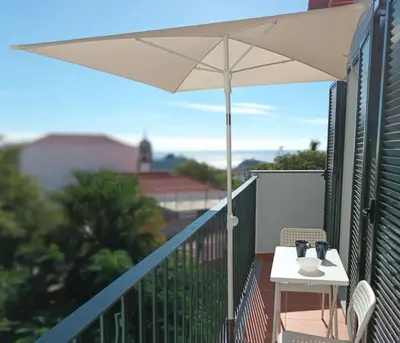 a kitchen with a wooden table and chairs and a kitchen with white cabinets at Alamos Charming Apartment - View in Funchal