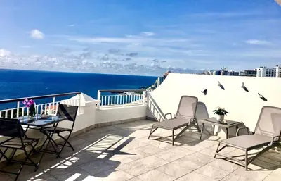 a patio with chairs and a table and the ocean at Endless Holiday 2 Bedroom Apartment Lido in Funchal