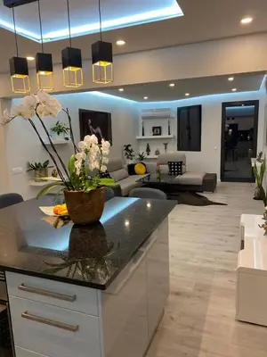 a kitchen and living room with a counter with flowers on it at Endless Holiday 2 Bedroom Apartment Lido in Funchal