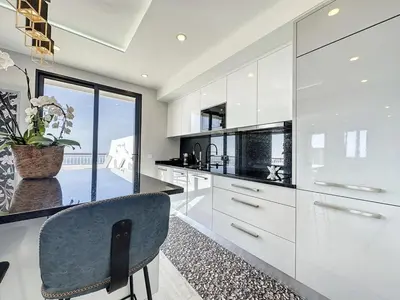 a kitchen with white cabinets and a blue chair at Endless Holiday 2 Bedroom Apartment Lido in Funchal