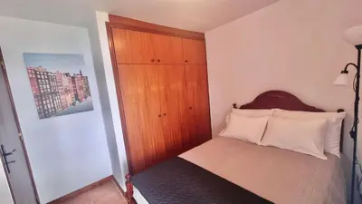 a small bedroom with a bed with a wooden door at Amélia's House in Seixal