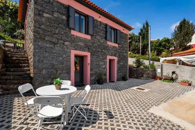 a patio with a table and chairs in front of a house at Casa da Cristina in Santa Cruz