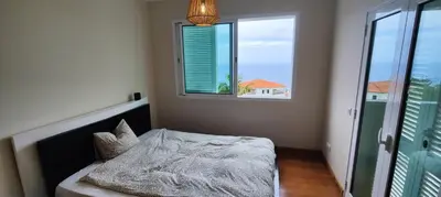 a bedroom with a bed and a large window at VillaMadeira - Apartments in Funchal in Funchal
