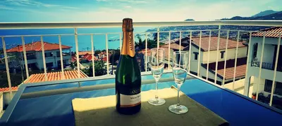 a bottle of wine and two glasses on a balcony at VillaMadeira - Apartments in Funchal in Funchal