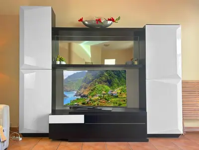 a television in a white entertainment center with a tv at VillaMadeira - Apartments in Funchal in Funchal