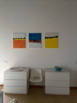 a white room with paintings on the wall at Vivenda Nina in Porto Santo