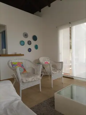 a living room with wicker chairs and a glass table at Vivenda Nina in Porto Santo