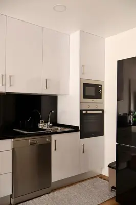 a kitchen with white cabinets and a microwave at Filipe's Green Landscape in Tábua