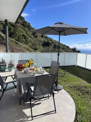 a table and chairs with an umbrella on a patio at Filipe's Green Landscape in Tábua
