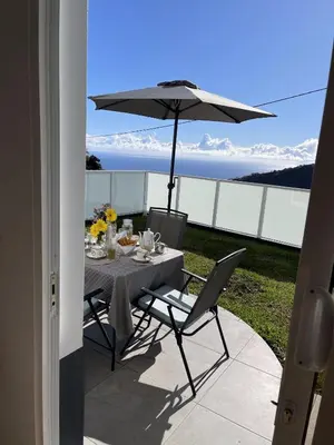 a table and chairs with an umbrella on a patio at Filipe's Green Landscape in Tábua