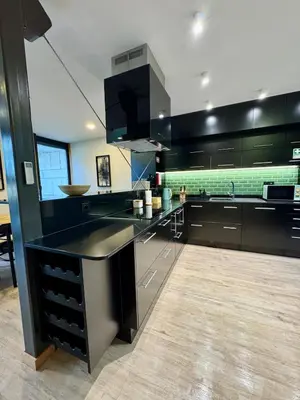 a kitchen with black cabinets and a counter top at Square house in Funchal