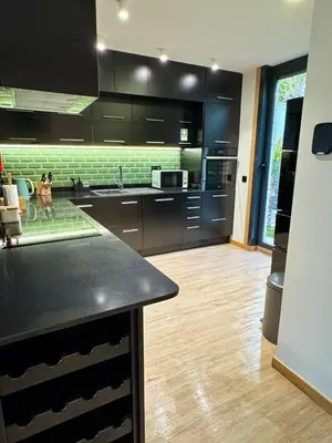 a kitchen with black cabinets and a black counter top at Square house in Funchal