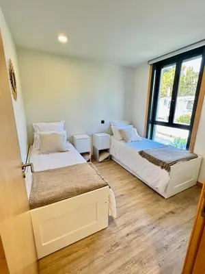 two beds in a room with a window at Square house in Funchal
