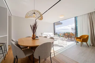 a dining room and living room with a table and chairs at Savoy Residence Monumentalis 2B or Not 2B by LM&AC Signature in Funchal