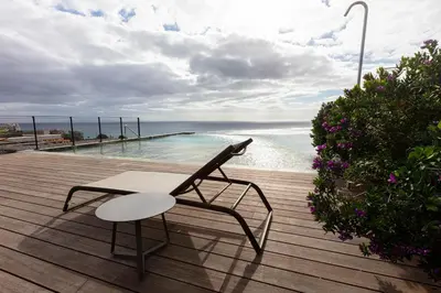 a wooden deck with a bench and a swimming pool at Savoy Residence Monumentalis 2B or Not 2B by LM&AC Signature in Funchal