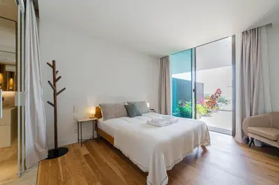 a white bedroom with a bed and a large window at Savoy Residence Monumentalis 2B or Not 2B by LM&AC Signature in Funchal