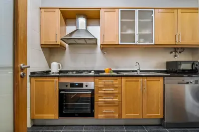 a kitchen with wooden cabinets and a stove top oven at Pilar Hills Apartment Funchal, By OP in Funchal