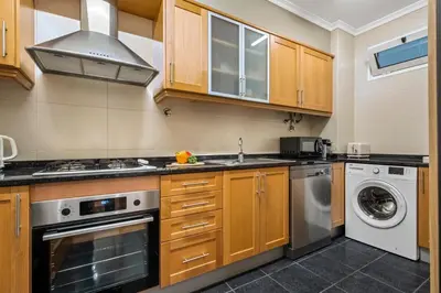 a kitchen with wooden cabinets and a washer and dryer at Pilar Hills Apartment Funchal, By OP in Funchal