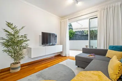 a living room with a gray couch and a tv at Pilar Hills Apartment Funchal, By OP in Funchal
