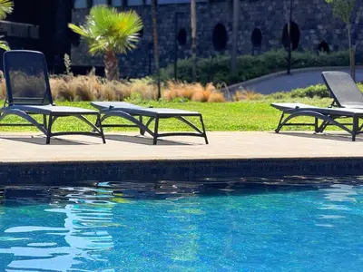 two lawn chairs sitting next to a swimming pool at Virtudes Charm in Funchal