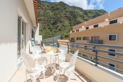 a white bench on a balcony with a mountain at HappyStay by Atlantic Holiday in Ribeira Brava