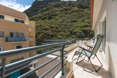 a balcony with a table and chairs and a mountain at HappyStay by Atlantic Holiday in Ribeira Brava