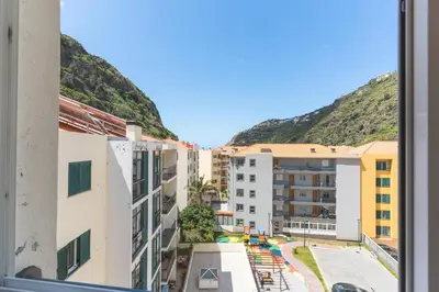 an aerial view of buildings with mountains in the background at HappyStay by Atlantic Holiday in Ribeira Brava