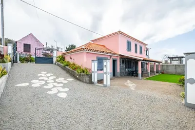 a pink house with a driveway at Casa Rocha in Fajã da Ovelha