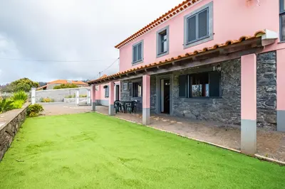 a house with a green lawn in front of it at Casa Rocha in Fajã da Ovelha