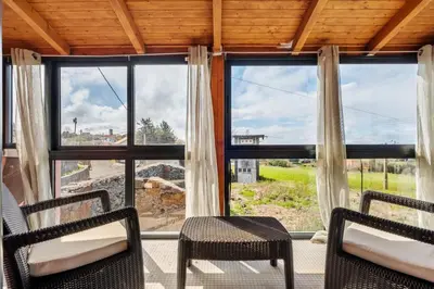 a room with two chairs and a large window at Casa Rocha in Fajã da Ovelha