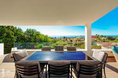 a dining room with a table and chairs on a patio at 180 degree Ocean Views, Pure Paradise in Luz