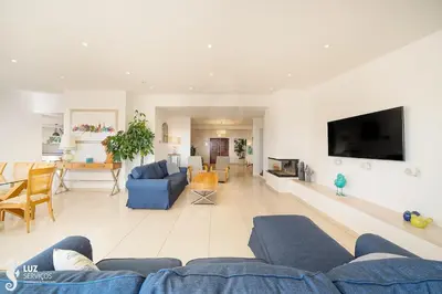 a living room with a blue couch and a tv at 180 degree Ocean Views, Pure Paradise in Luz