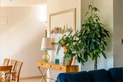 a living room with a blue couch and a table with a plant at 180 degree Ocean Views, Pure Paradise in Luz