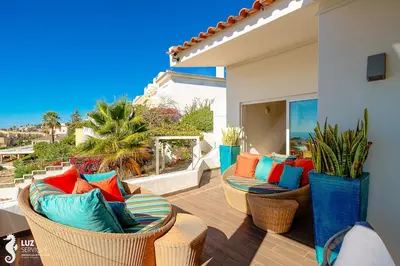 a patio with wicker chairs and colorful pillows at 180 degree Ocean Views, Pure Paradise in Luz