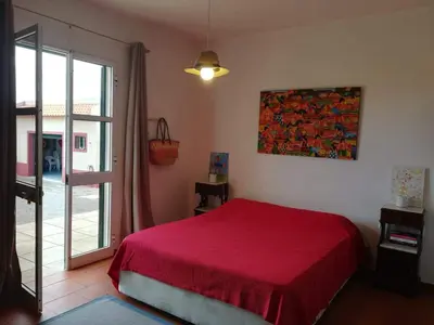 a bedroom with a red bed and a sliding glass door at Villa Antonius in Porto Santo