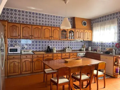 a kitchen with wooden cabinets and a wooden table at Villa Antonius in Porto Santo