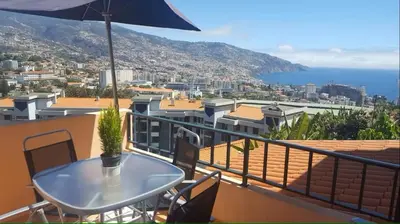 a balcony with a table and a view of the city at Funchal - Breathtaking ocean & city view house in Funchal