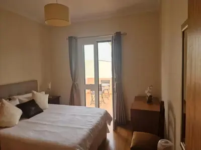 a bedroom with a bed and a door to a balcony at Funchal - Breathtaking ocean & city view house in Funchal