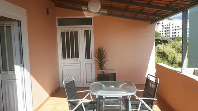 a table and chairs on a balcony with a door at Funchal - Breathtaking ocean & city view house in Funchal